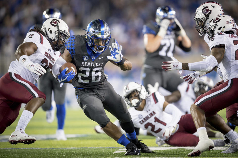 Kentucky running back Benny Snell Jr. (26) carries the ball between several South Carolina defenders in Lexington, Kentucky, on Sept. 29, 2018. (AP Photo/Bryan Woolston)