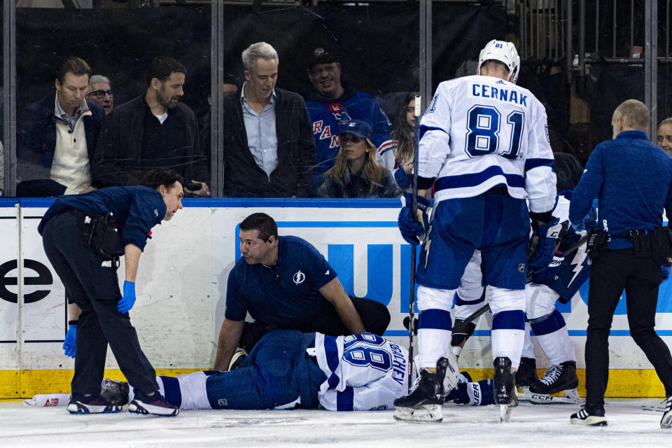 CORRECTS ID OF INJURED PLAYER TO MIKHAIL SERGACHEV - Tampa Bay Lightning medical staff tend to Mikhail Sergachev (98) after he sustained a leg injury during the second period of an NHL hockey game against the New York Rangers on Wednesday, Feb. 7, 2024 in New York. (AP Photo/Peter K. Afriyie)