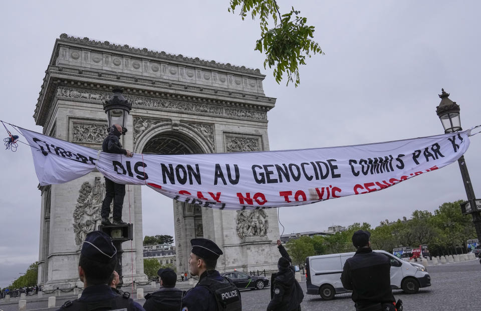 Police officers take down a banner setup by free Tibet activists to protest the visit of Chinese President Xi Jinping to France, next to the Arc de Triomphe in Paris, Saturday May 4, 2024. Xi Jinping will start the European tour in Paris on Monday, meeting with French President Emmanuel Macron. (AP Photo/Michel Euler)