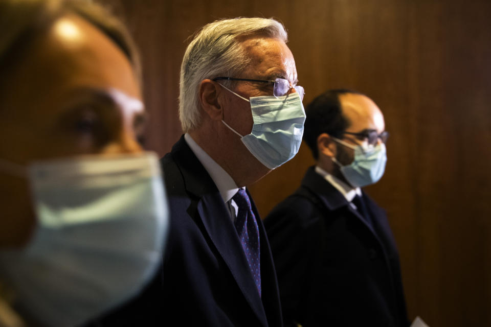 European Commission's Head of Task Force for Relations with the United Kingdom Michel Barnier, center, arrives to the main chamber of the European Parliament in Brussels, Friday, Dec. 18, 2020. Barnier said that the bloc and the United Kingdom were starting a "last attempt" to clinch a post-Brexit trade deal, with EU fishing rights in British waters the most notable remaining obstacle to avoid a chaotic and costly changeover on New Year. (AP Photo/Francisco Seco)