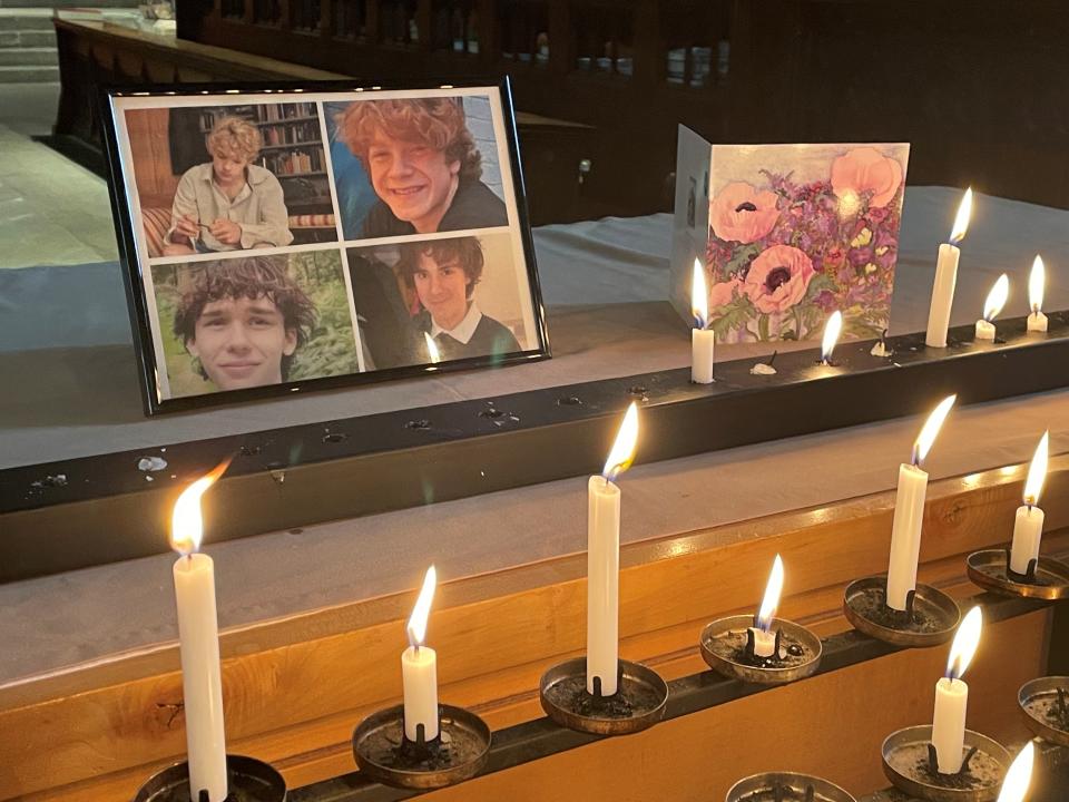 A photo of the four teenagers,  Jevon Hirst, Harvey Owen, Wilf Fitchett and Hugo Morris, who died in a car crash in Snowdonia, North Wales, by candles and a sympathy card inside Shrewsbury Abbey (PA)