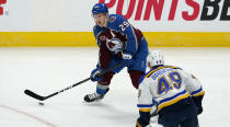 Colorado Avalanche center Nathan MacKinnon, back, looks to pass the puck as St. Louis Blues center Ivan Barbashev defends in the first period of an NHL hockey game Friday, Jan. 15, 2021, in Denver. (AP Photo/David Zalubowski)