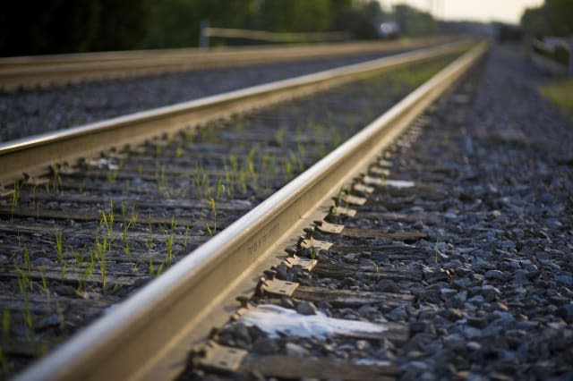 A close up of a set of train tracks at sunset.