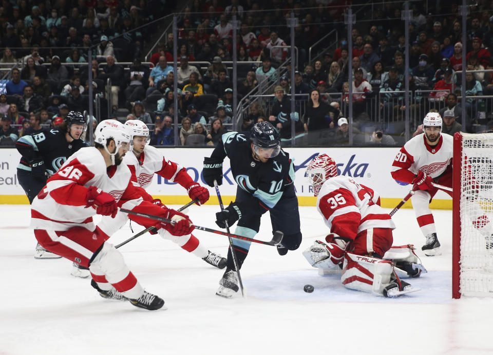 Detroit Red Wings goaltender Ville Husso (35) blocks a shot from Seattle Kraken center Matty Beniers (10) during the second period of an NHL hockey game Saturday, Feb. 18, 2023, in Seattle. (AP Photo/ Lindsey Wasson)