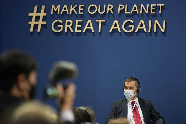 A sign that says "#Make Our Planet Great Again" above a person's head