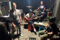 Noodles shop owner and a rock band singer Wang Zongxing rehearses with his band at a studio in Shenzhen