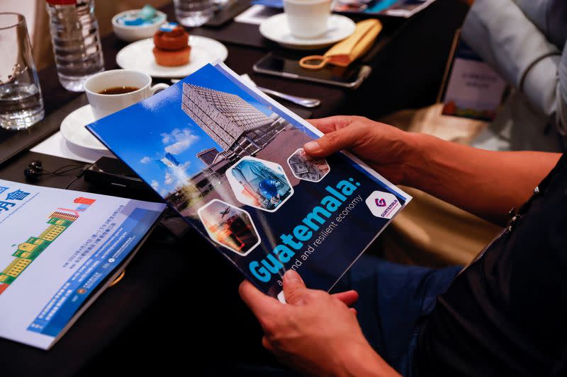 A person holds a booklet about Guatemala at an investment event in Taipei