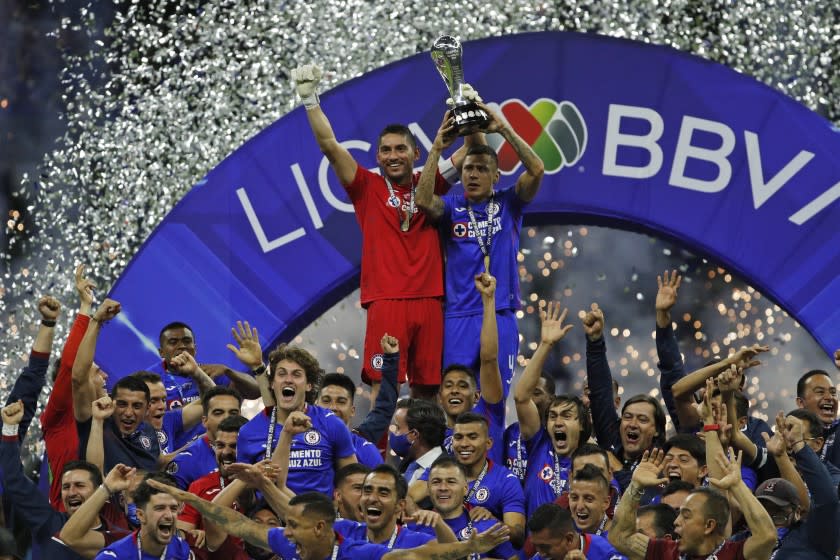 Cruz Azul's goalkeeper Jose Corona, left, and Julio Dominguez lift the trophy after winning the final Mexican soccer league championship match against Santos at Azteca stadium in Mexico City, Sunday, May 30, 2021. (AP Photo/Eduardo Verdugo)