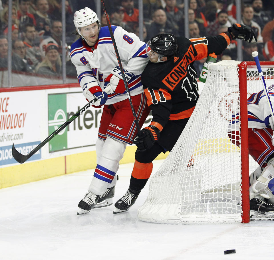 New York Rangers' Jacob Trouba shoves Philadelphia Flyers' Travis Konecny into the net as the two chase the puck during the second period of an NHL hockey game, Monday, Dec. 23, 2019, in Philadelphia. (AP Photo/Tom Mihalek)