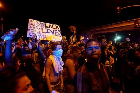 Protesters gather along Mollison Avenue to protest the fatal shooting of an unarmed black man on Tuesday by officers in El Cajon, California. REUTERS/Sandy Huffaker