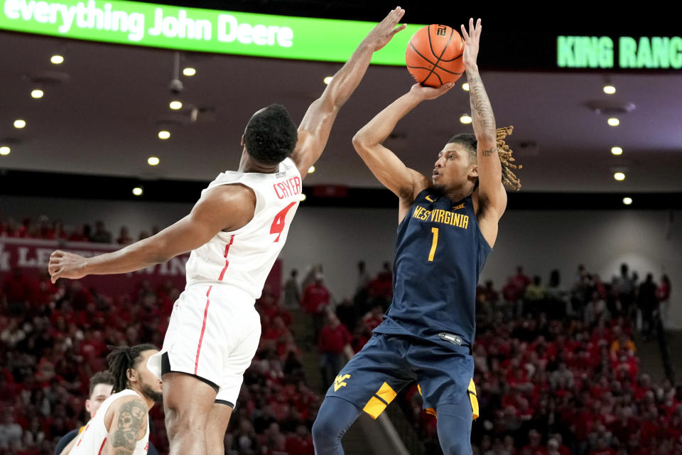 West Virginia guard Noah Farrakhan (1) shoots as Houston guard L.J. Cryer defends during the second half of an NCAA college basketball game Saturday Jan. 6, 2024, in Houston. (AP Photo/Eric Christian Smith)