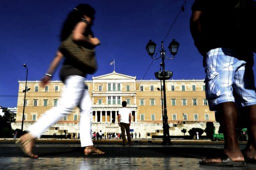 People walk by the Greek parliament in Athens. The Greek conservative and socialist parties have suffered massive losses in an election marked by anti-austerity anger, with a leftist party opposing EU-IMF reforms making gains, exit polls showed