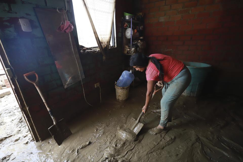 Una mujer palea lodo dentro de su casa inundada por las fuertes lluvias en Lambayeque, Perú, el sábado 11 de marzo de 2023. (AP Foto/Jao Yamunaque)