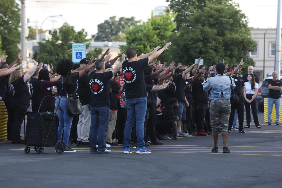 Employees listen to a speech and prayer before heading in to Tops Friendly Market on Jefferson Ave, in Buffalo, NY on Friday, July 15, 2022. Workers held up their hands to bless the store.   The store opened two months after 10 people were killed and three injured in a mass shooting that targeted Black people.