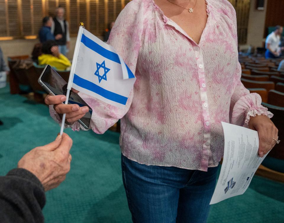 A flag of Israel is handed out at Congregation Beth-El Zedeck, on Monday, Oct. 9, 2023. The synagogue service comes two days after the start of a potentially lengthy war involving Israel and Hamas.
