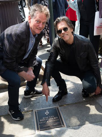 <p>Lisa Lake/Getty</p> Michael Bacon and Kevin Bacon pose by their plaque at the 2023 Philadelphia Music Alliance Walk of Fame plaque unveilings.