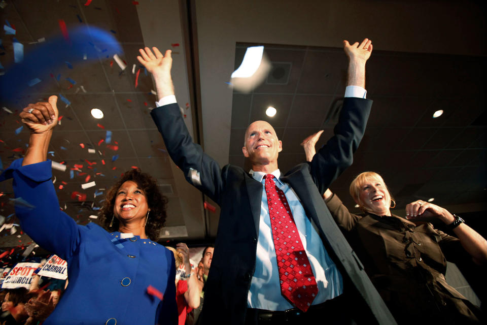 Then Florida Gov.-elect Rick Scott his wife Ann, right, and Lt. Gov.-elect Jennifer Carroll, left, wave to supporters after Scott's victory speech, in Fort Lauderdale, Fla. on Nov. 3, 2010.<span class="copyright">Wilfredo Lee—AP</span>