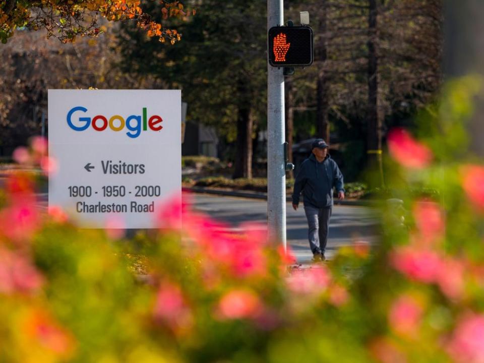  A pedestrian walks past directional signage at the Google campus in Mountain View, California, U.S.