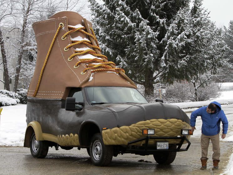 A man wipes off the headlights of the L.L. Bean Bootmobile in the parking lot at the facility where the famous outdoor boot is made. (AP Photo/Pat Wellenbach)