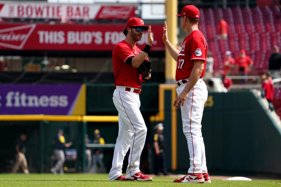 Cincinnati Reds right fielder Tyler Naquin (12) and Cincinnati Reds catcher Tyler Stephenson (37) exchange high fives at the conclusion of a baseball game against the Milwaukee Brewers, Wednesday, May 11, 2022, at Great American Ball Park in Cincinnati. The Cincinnati Reds won, 14-11.