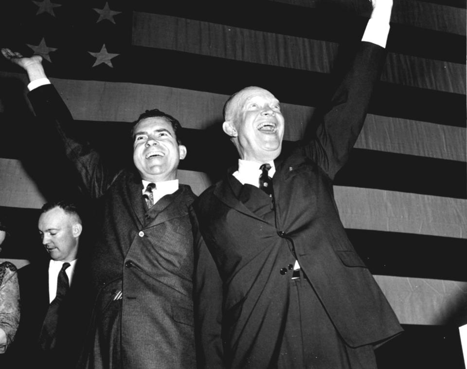 FILE - With upraised arms, President Dwight D. Eisenhower and Vice President Richard Nixon salute cheering workers and Republicans at Republican election headquarters in Washington, Nov. 7, 1956, after Adlai Stevenson conceded, with the Republicans winning in a landslide. (AP Photo, File)