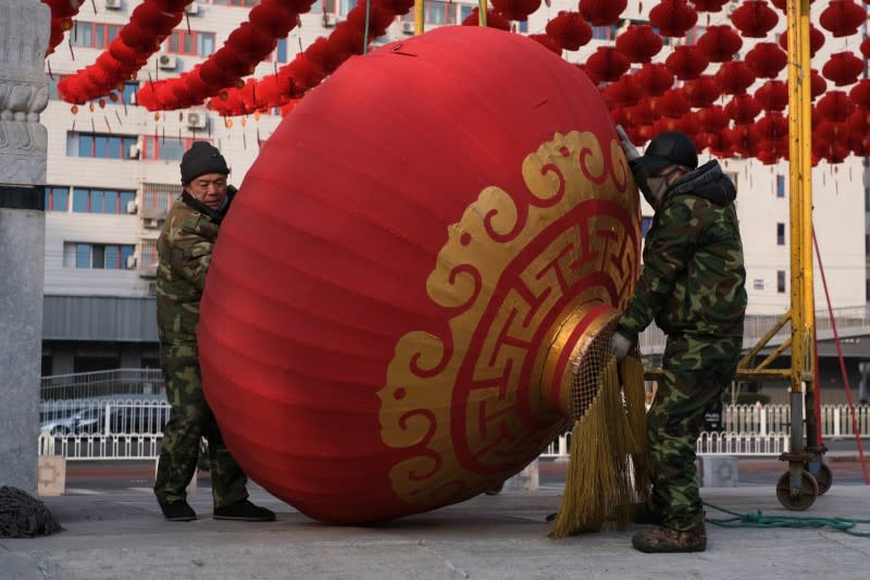 Workers dismantle decorations after the temple fair for the Chinese Lunar New Year in Ditan Park was canceled in Beijing