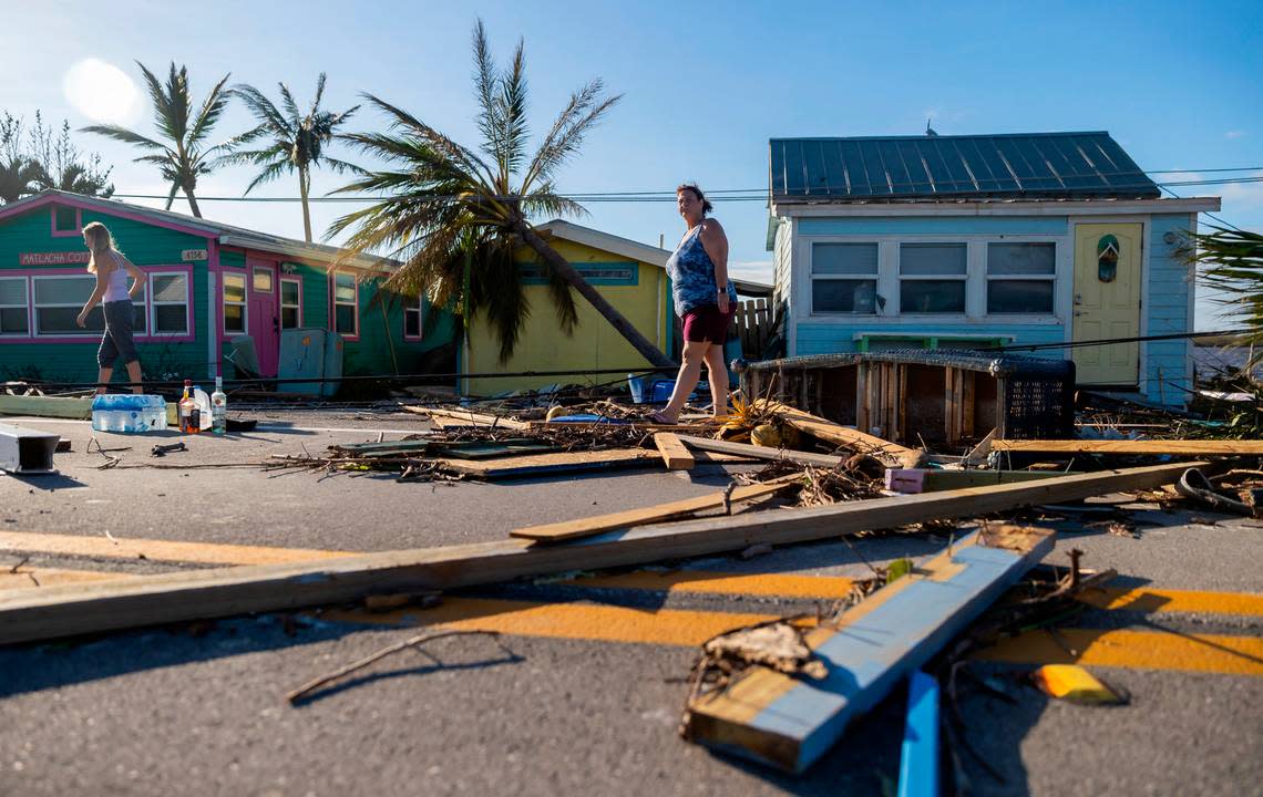 Donna LaMountain, 51, surveys damage on Pine Island Road on Thursday, Sept. 29, 2022, in Matlacha, Florida. Hurricane Ian made landfall on the coast of Southwest Florida as a Category 4 storm the afternoon before, leaving areas affected with flooded streets, downed trees and scattered debris.