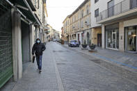 A man wearing a sanitary mask walks in a street in Codogno, near Lodi in Northern Italy, Friday, Feb. 21,2020. Health officials reported the country's first cases of contagion of COVID-19 in people who had not been in China. The hospital in Codogno is one of the hospitals - along with specialized Sacco Hospital in Milan - which is hosting the infected persons and the people that were in contact with them and are being isolated. (AP Photo/Luca Bruno)