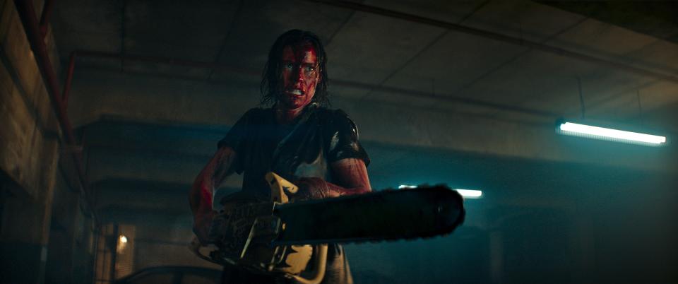 Lily Sullivan strikes a familiar "Evil Dead" pose – drenched in blood and wielding a chainsaw – in "Evil Dead Rise."