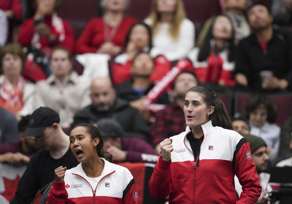 Canada's Leylah Fernandez, left, and Rebecca Marino cheer on teammate Katherine Sebov as she plays Belgium's Greet Minnen during a Billie Jean King Cup tennis qualifier singles match Saturday, April 15, 2023, in Vancouver, British Columbia. (Darryl Dyck/The Canadian Press via AP)
