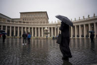 A priest walks in the empty St. Peter's Square as Pope Francis is delivering the Angelus noon prayer from his studio, at the Vatican, Sunday, Jan. 17, 2021. (AP Photo/Andrew Medichini)