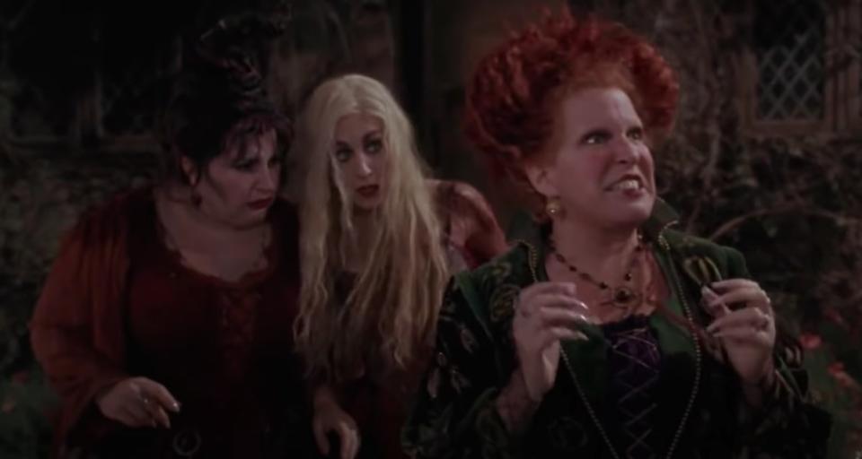 The Sanderson sisters stand in front of their house looking angry and perlexed