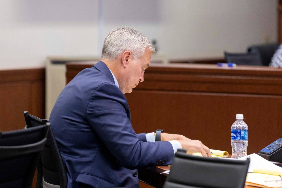 John Tilley, who is charged with rape, looks down at notes during the trial against him.