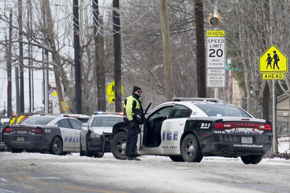 A Dallas police presence is seen at the street intersection of Belmont and Henderson in a neighborhood where earlier in the day two other officers were shot responding to an emergency call in Dallas, Thursday, Feb. 18, 2021. (AP Photo/Tony Gutierrez)