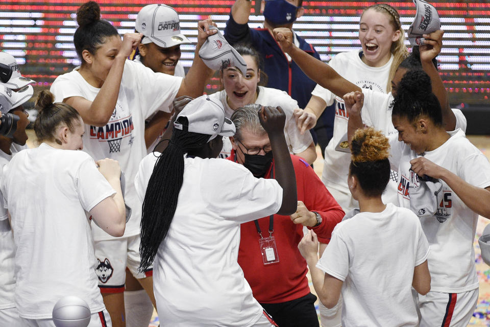 Connecticut head coach Geno Auriemma, center, dances with his team in celebration of their NCAA college basketball game win in the Big East tournament finals against Marquette at Mohegan Sun Arena, Monday, March 8, 2021, in Uncasville, Conn. (AP Photo/Jessica Hill)