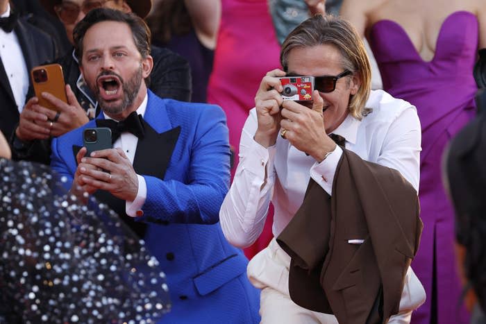 Nick Kroll and Chris Pine holding cameras