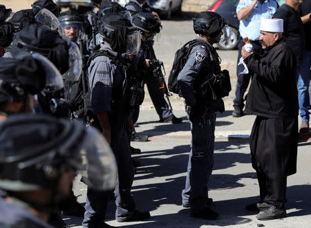 An Israeli policeman talks with a Druze protester outside a polling station in Majdal Shams, October 30, 2018. REUTERS/Ammar Awad