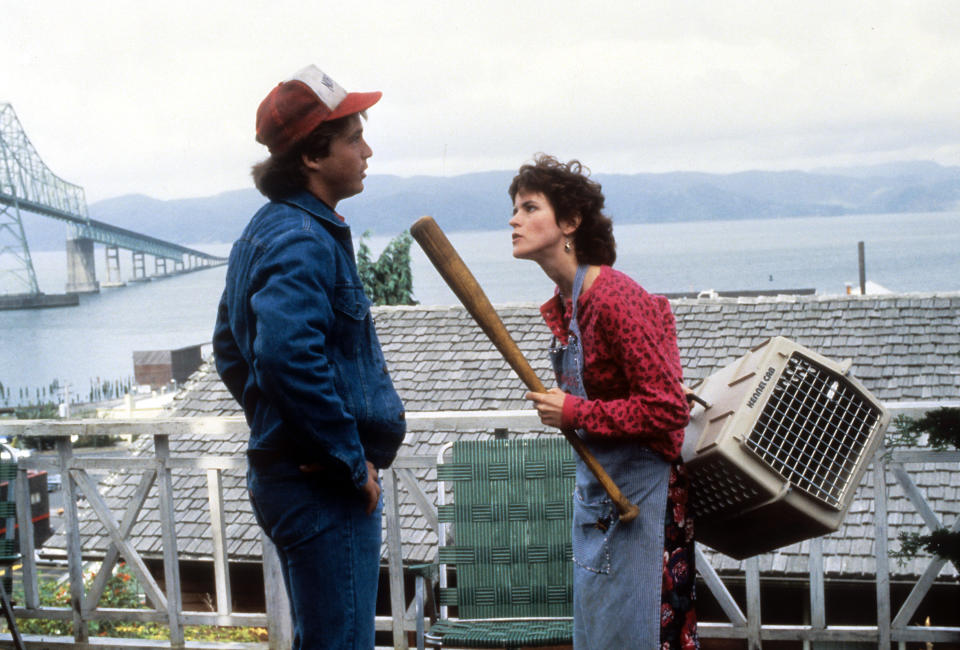 Steve Guttenberg standing in front of Ally Sheedy while she threatens him with a bat in a scene from the film 'Short Circuit', 1986. (Photo by  David Foster Productions/Getty Images)