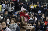 A statue of a girl representing thousands of Korean women enslaved for sex by Japan's imperial forces before and during World War II, is seen during a weekly rally near the Japanese Embassy in Seoul, South Korea, Wednesday, Jan. 30, 2019. Hundreds of South Koreans are mourning the death of a former sex slave for the Japanese military during World War II by demanding reparations from Tokyo over wartime atrocities. (AP Photo/Lee Jin-man)