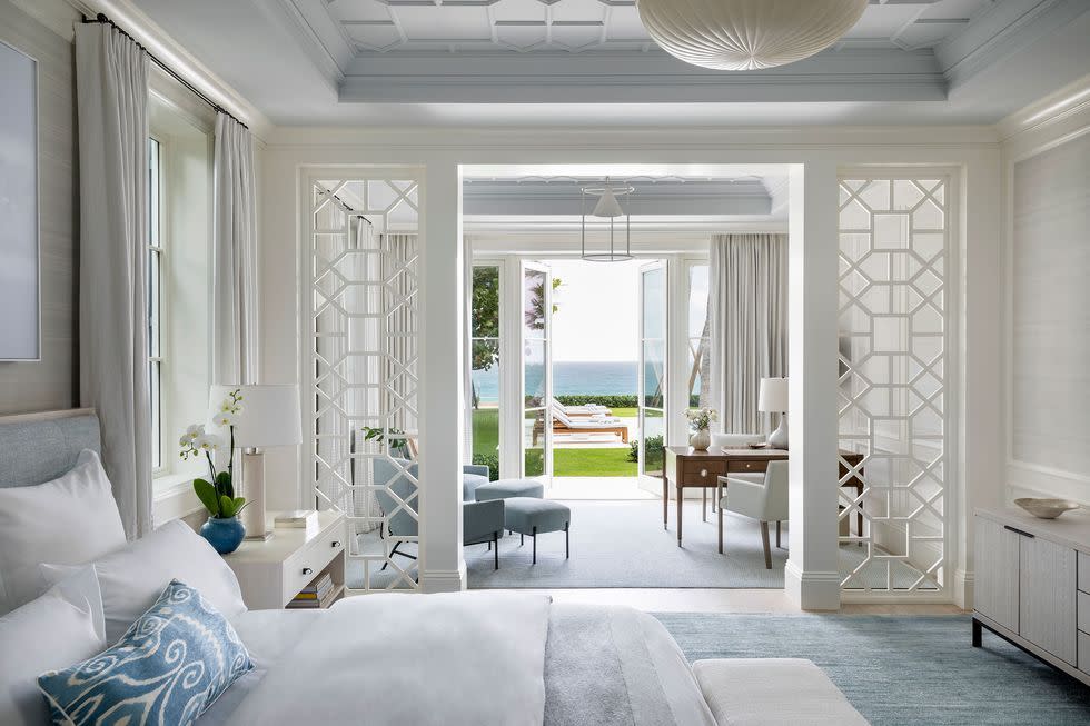 a room with a glass door and a table with chairs and a white table with a white table