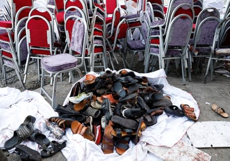 The shoes of victims are seen outside a damaged wedding hall after a blast in Kabul, Afghanistan