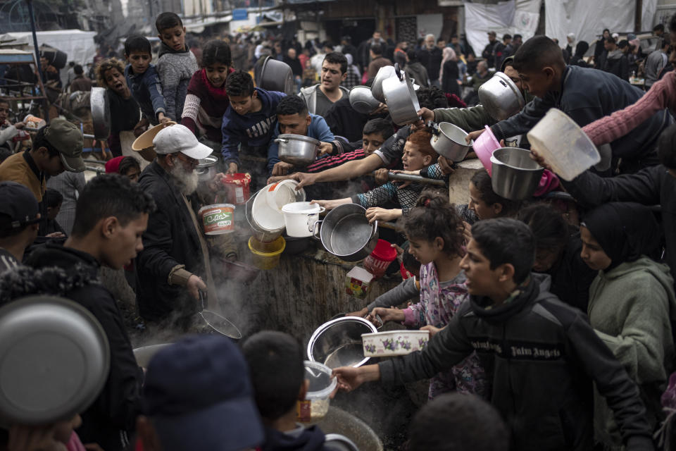 Palestinians line up for a free meal in Rafah, Gaza Strip, Thursday, Dec. 21, 2023. International aid agencies say Gaza is suffering from shortages of food, medicine and other basic supplies as a result of the two and a half month war between Israel and Hamas. (AP Photo/Fatima Shbair)