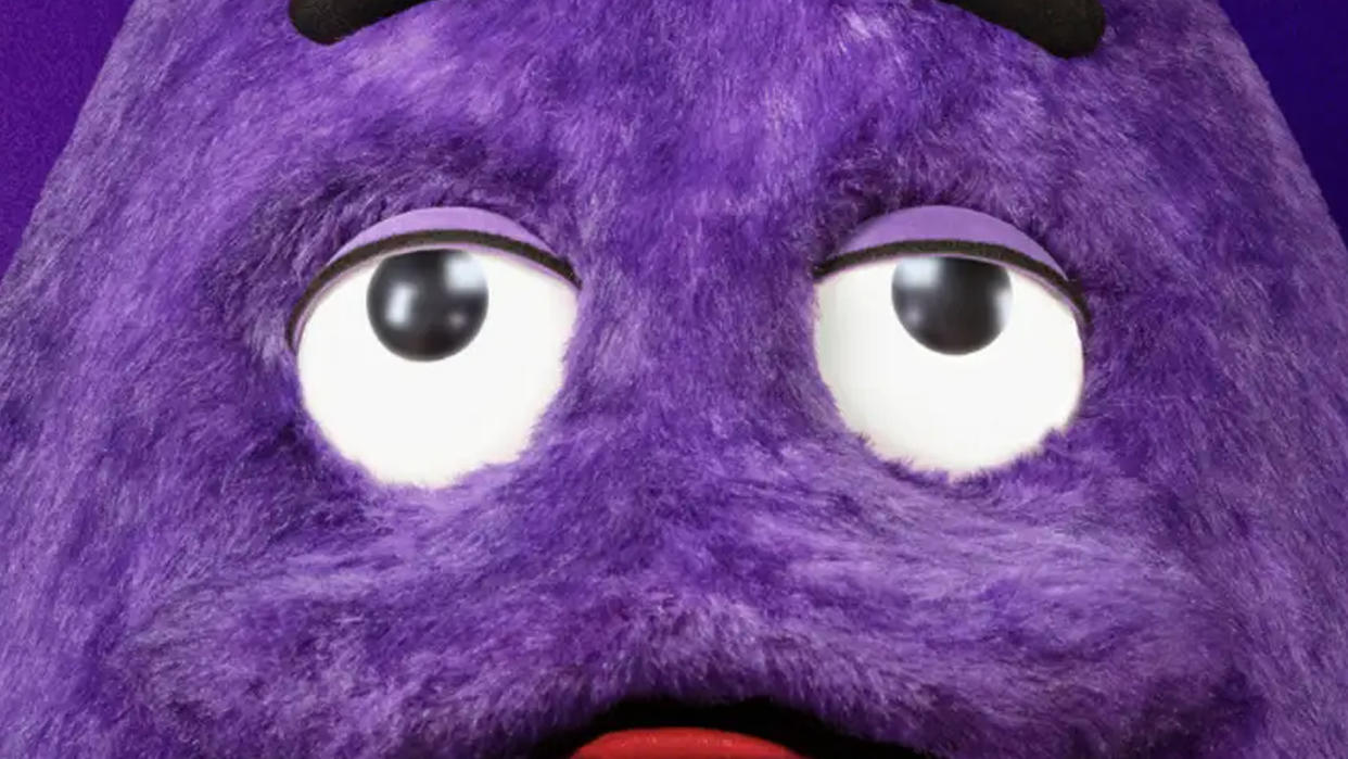  Grimace, a big purple mascot from McDonalds, looks up at something off-screen. 