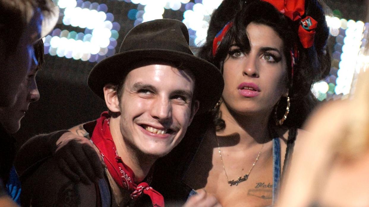 blake fielder civil smiling as he embraces a concerned looking amy winehouse