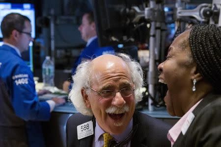 Traders laugh as they work on the floor of the New York Stock Exchange as the market closes in New York October 17, 2014. REUTERS/Lucas Jackson
