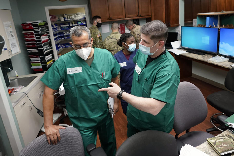 FILE - In this July 16, 2020 file photo, Registered nurses Army Lt. Col. Oswaldo Martinez, left, and Maj. Andrew Wieher, right, with the Urban Augmentation Medical Task Force, work to setup a nurses station inside a wing at United Memorial Medical Center, in Houston. Texas reported a new daily record for virus deaths Friday and more than 10,000 confirmed cases for the fourth consecutive day. (AP Photo/David J. Phillip)