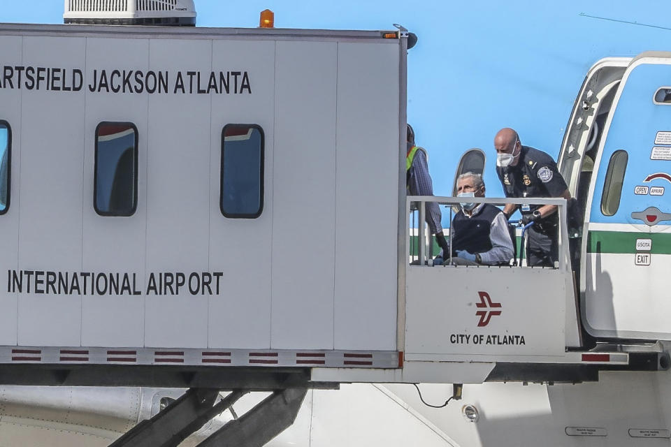 American and Canadian cruise ship passengers from the Costa Luminosa arrive at Atlanta's Hartsfield-Jackson International Airport, near Atlanta , Friday, March 20, 2020. Three people on the flight have tested positive for COVID-19 but have no symptoms, while 13 others are sick but haven't been tested, the U.S. Department of Health and Human Services said Friday. (John Spink/Atlanta Journal-Constitution via AP)