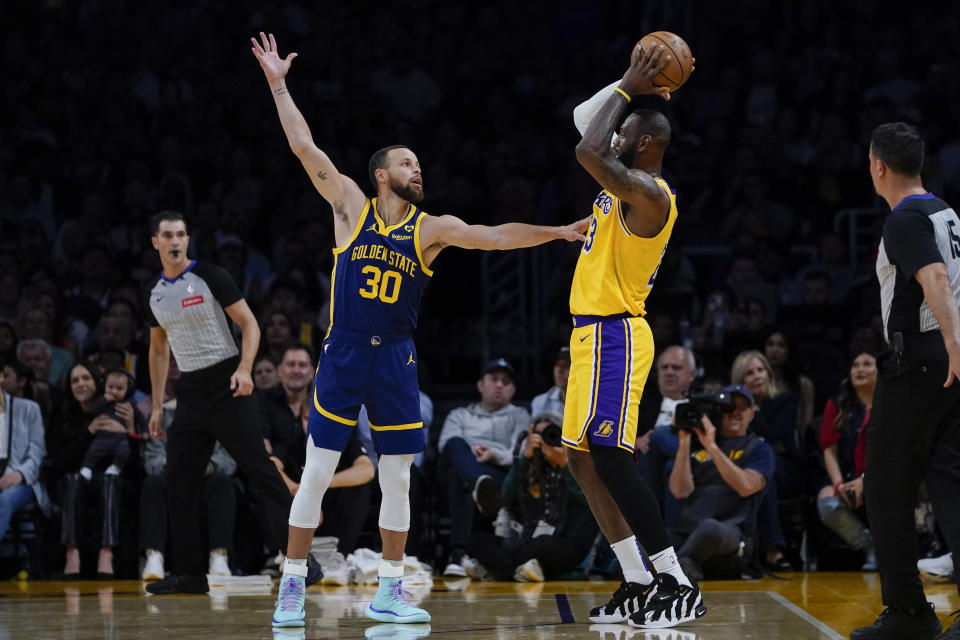 Golden State Warriors guard Stephen Curry, left, guards Los Angeles Lakers forward LeBron James during the first half of an NBA basketball game, Tuesday, April 9, 2024, in Los Angeles. (AP Photo/Ryan Sun)