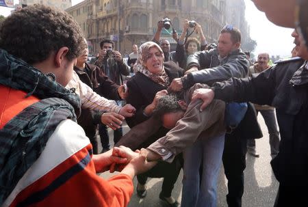 Supporters of an anti-Muslim Brotherhood group hit a supporter of ousted Egyptian President Mohamed Mursi and the Muslim Brotherhood at Talaat Harb Square in Cairo, January 25, 2015. REUTERS/Mohamed Abd El Ghany