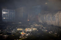 In this photo released by the Syrian official news agency SANA, shows damaged containers at the scene of a missile attack, at the seaport of the coastal city of Latakia, Syria, Tuesday, Dec. 7, 2021. Syria’s military said Israeli warplanes fired the missiles causing fire without inflicting any human losses. Syria’s state media quoted an unnamed military official as saying that several missiles struck the containers area in the port early on Tuesday, setting some of them on fire. (SANA via AP)